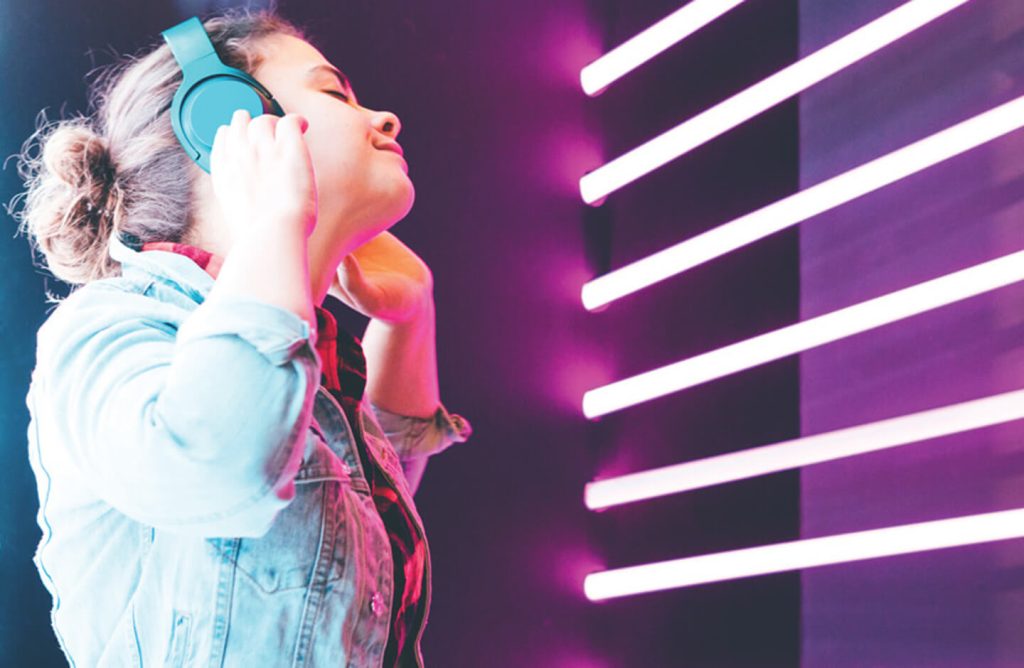 Smiling girl listening to music on headphones