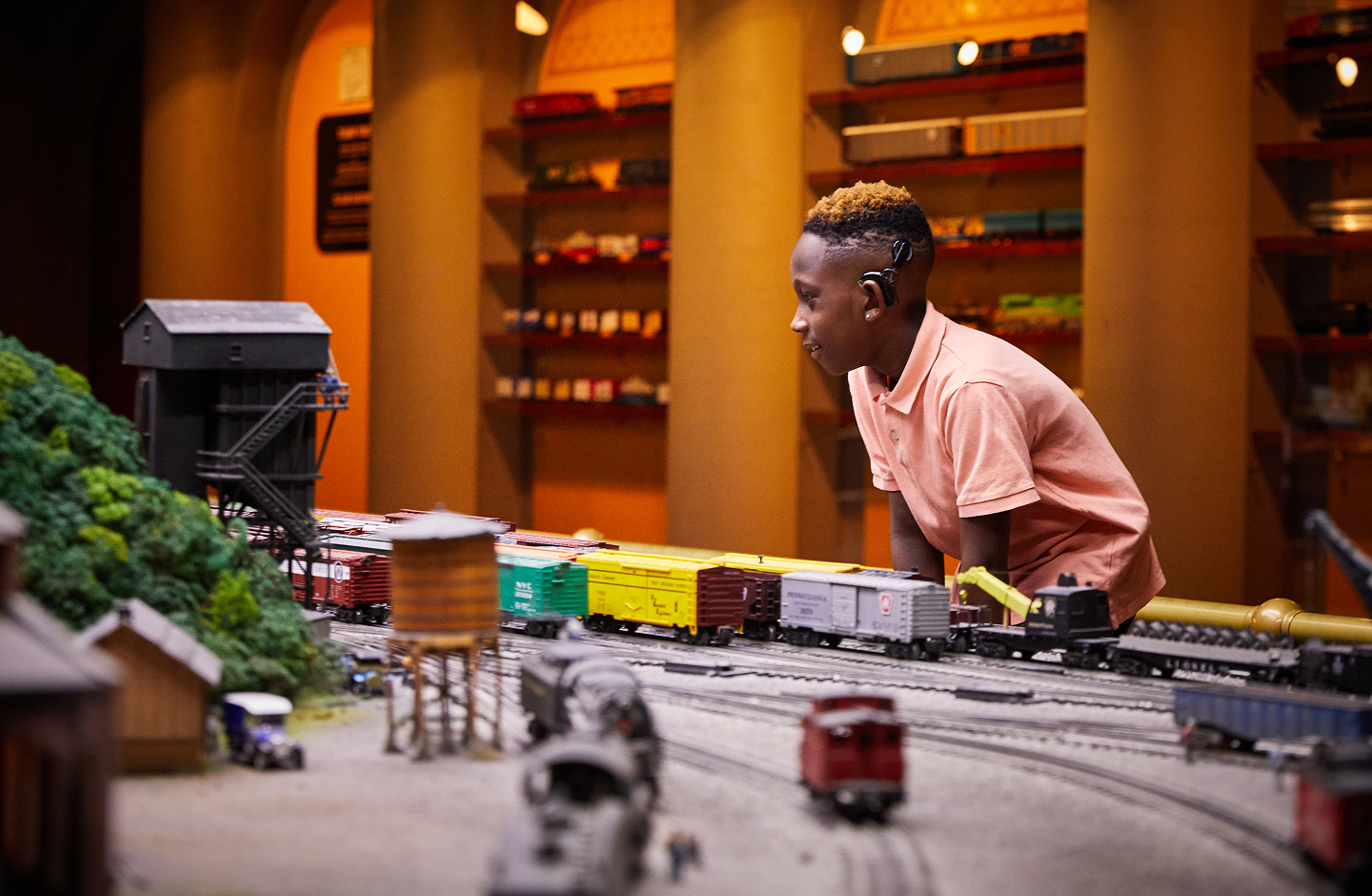 A boy watches a miniature railroad pass by.