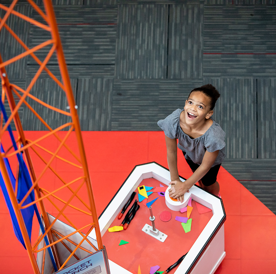 A young girl interacting with an exhibit at the Kamin Science Center.
