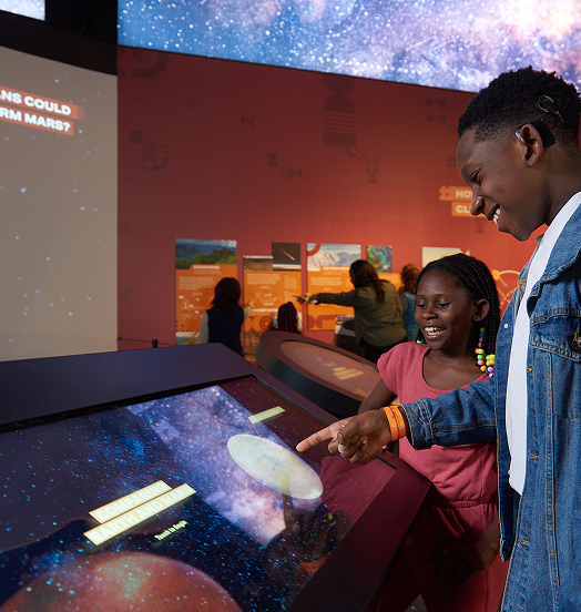 Two kids interact with a display in the Mars exhibit.