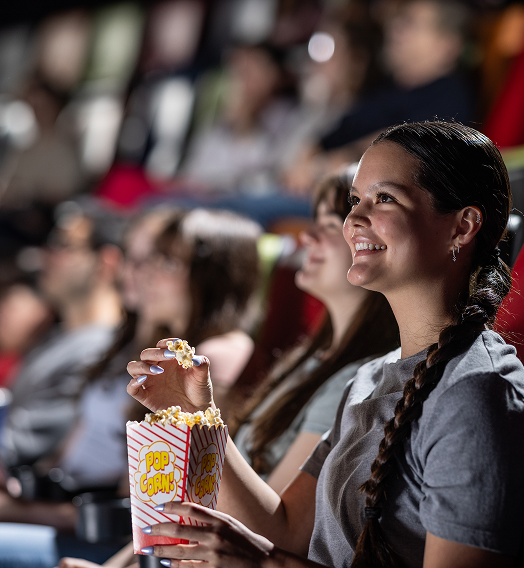 A teenage girl is watching a movie in the Rangos Giant Cinema.