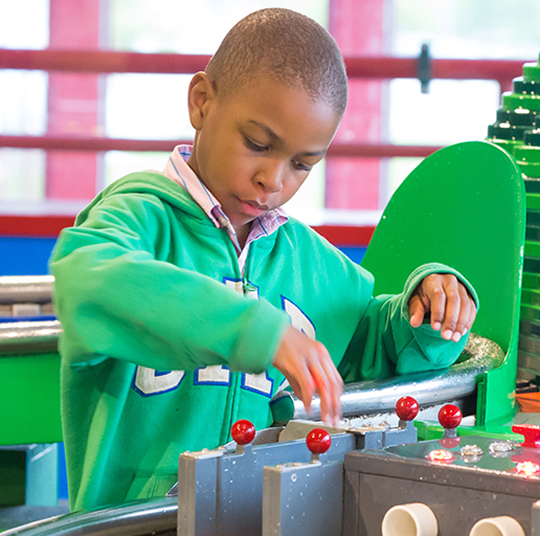 A boy interacts with an exhibit at the Kamin Science Center.