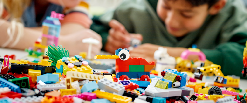 Two kids playing with Legos in the Bricksburgh exhibit.