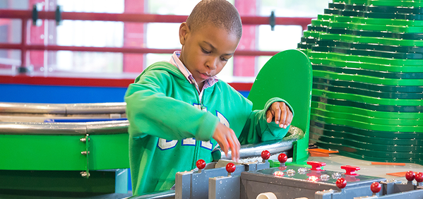 A young boy interacts with a water exhibit
