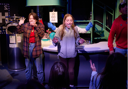 Two young girls participating in a science experiment with liquid nitrogen.