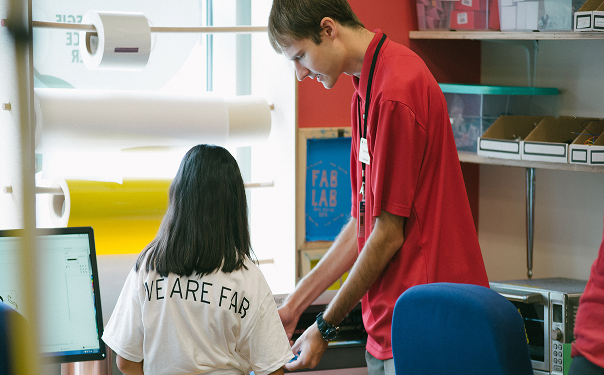 A Science Center staff member helps a young student complete a project in BNY Fab Lab.