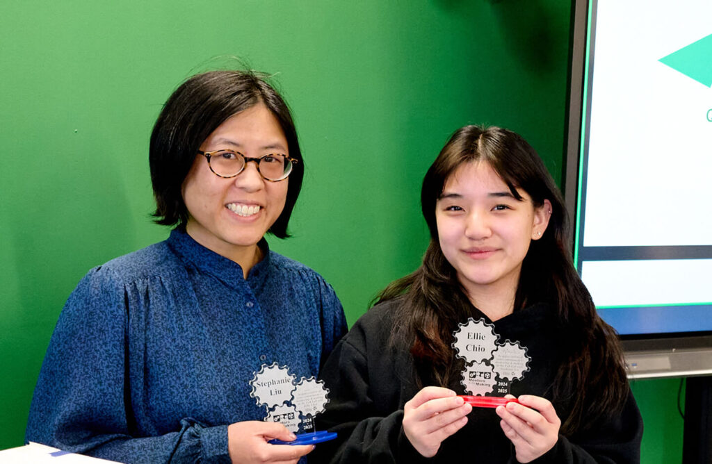Two people holding a laser-cut awards