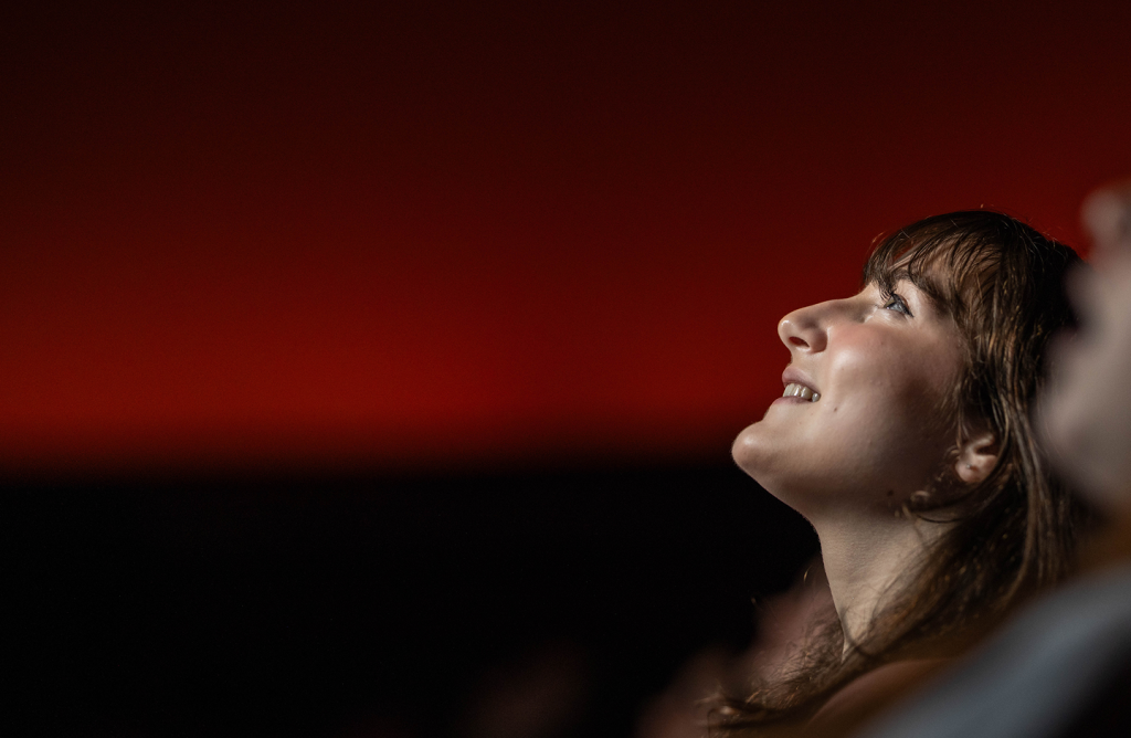 A teen girl is looking up at the ceiling in the Buhl Planetarium.