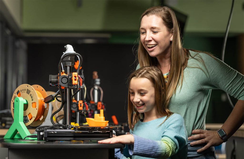 A mother and daughter using a 3D printer