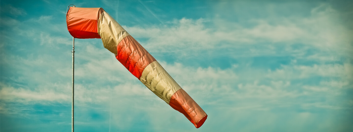 Wind bag blowing against a cloudy sky.