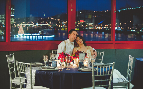 A wedding couple seated with the city of Pittsburgh behind them.