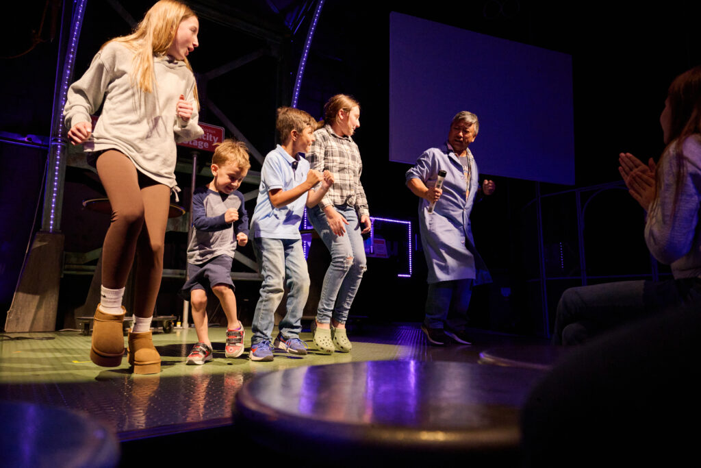 Visitors interacting on a stage during a live demonstration