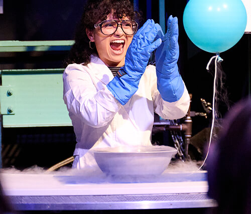 A staff educator A conducting an experiment with a blue balloon.